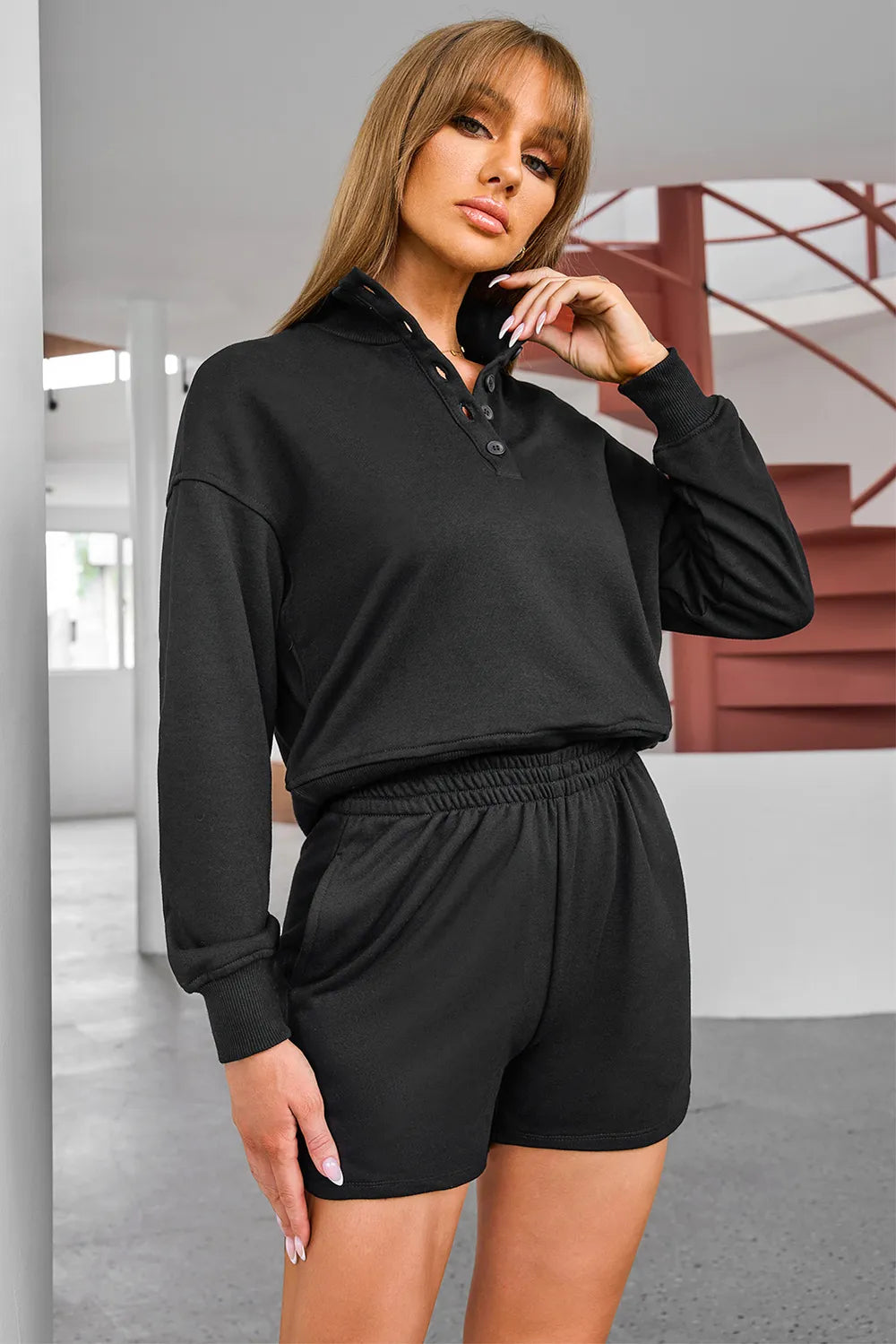oNMexis female model wearing a half-button black sweatshirt and shorts activewear set – casual workout outfit in soft fabric